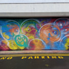 Painted shop shutters featuring brightly coloured bubbles; the bubbles have different facial expressions
